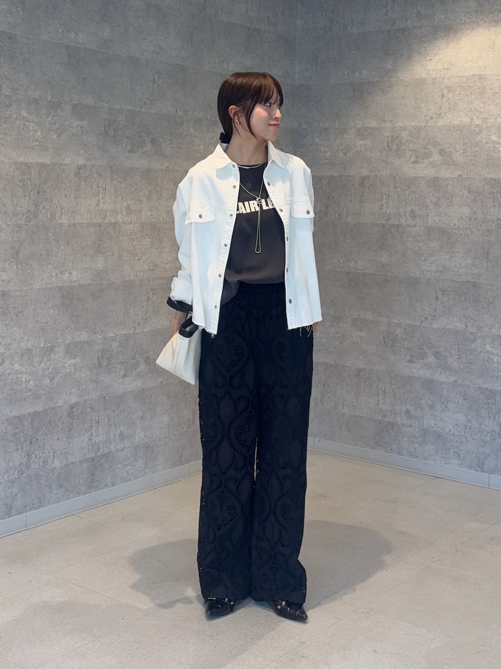 ホワイト系のショルダーバッグ、ブラック系のその他パンツ、グレー系のシャツ/ブラウスを着用したレディースの春コーディネートの2枚目の写真