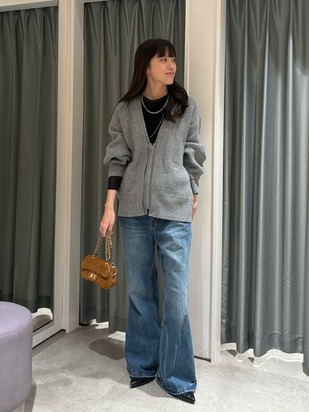 ブラック系のTシャツ/カットソー、グレー系のカーディガン/ボレロ、ブルー系のデニムパンツを着用したレディースの冬コーディネートの3枚目の写真