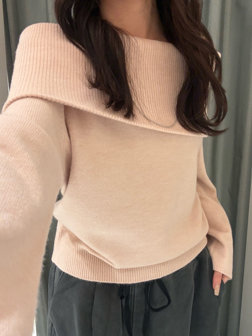 ピンク系のニット/セーター、ブラック系のその他パンツ、ホワイト系のショルダーバッグを着用したレディースの冬コーディネートの4枚目の写真