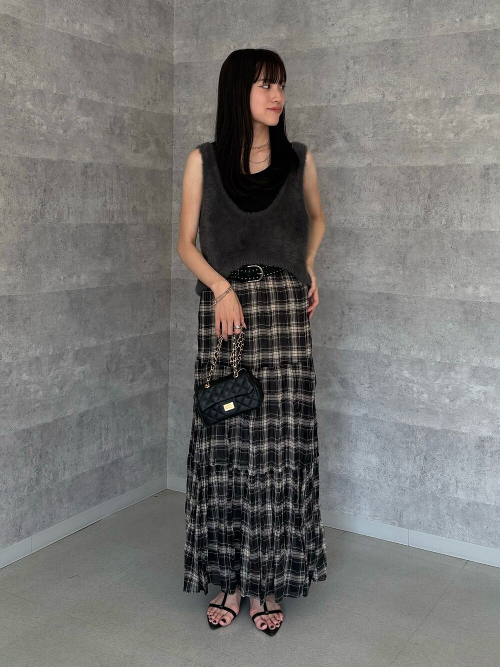 ブラック系のスカート、グレー系のニット/セーター、ブラック系のショルダーバッグを着用したレディースの夏コーディネートの2枚目の写真