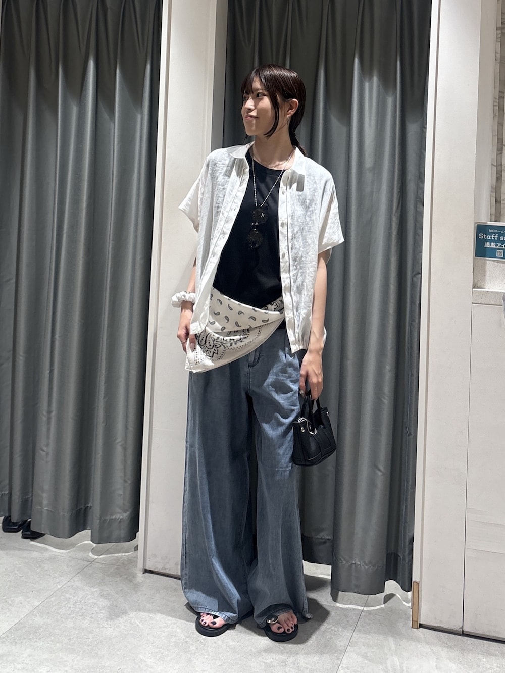 ホワイト系のシャツ/ブラウス、ブラック系のTシャツ/カットソー、ブルー系のデニムパンツを着用したレディースの夏コーディネートの4枚目の写真