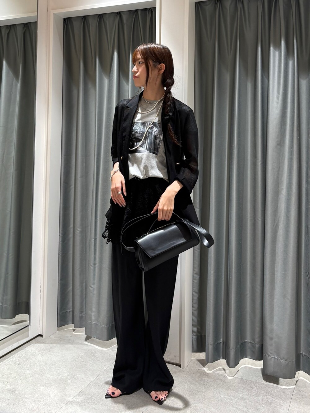 ブラック系のテーラードジャケット、グレー系のTシャツ/カットソー、ブラック系のショルダーバッグを着用したレディースの夏コーディネートの3枚目の写真