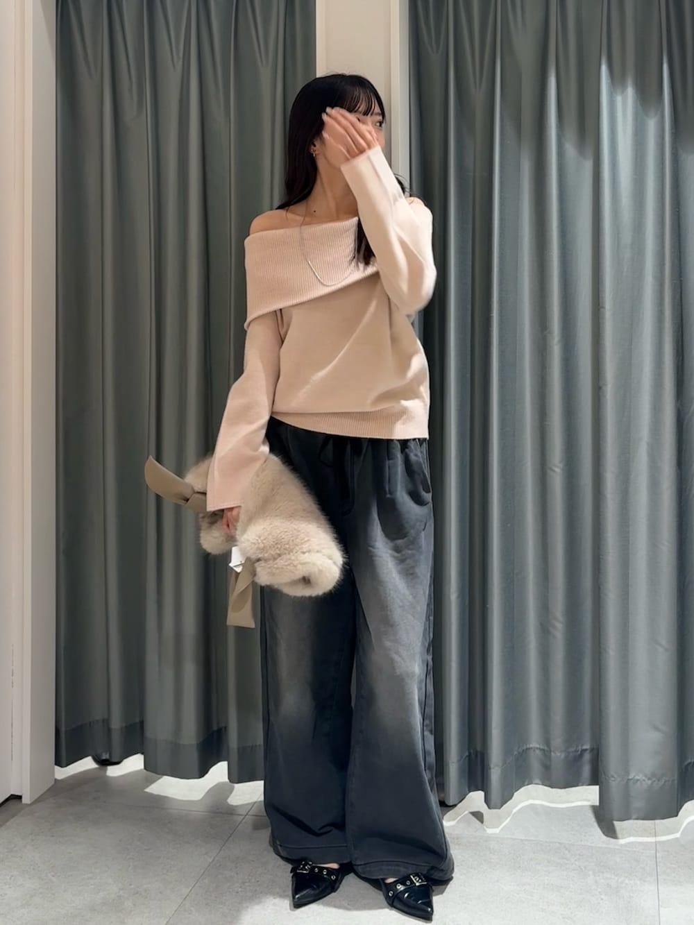 ピンク系のニット/セーター、ブラック系のその他パンツ、ホワイト系のショルダーバッグを着用したレディースの冬コーディネートの2枚目の写真