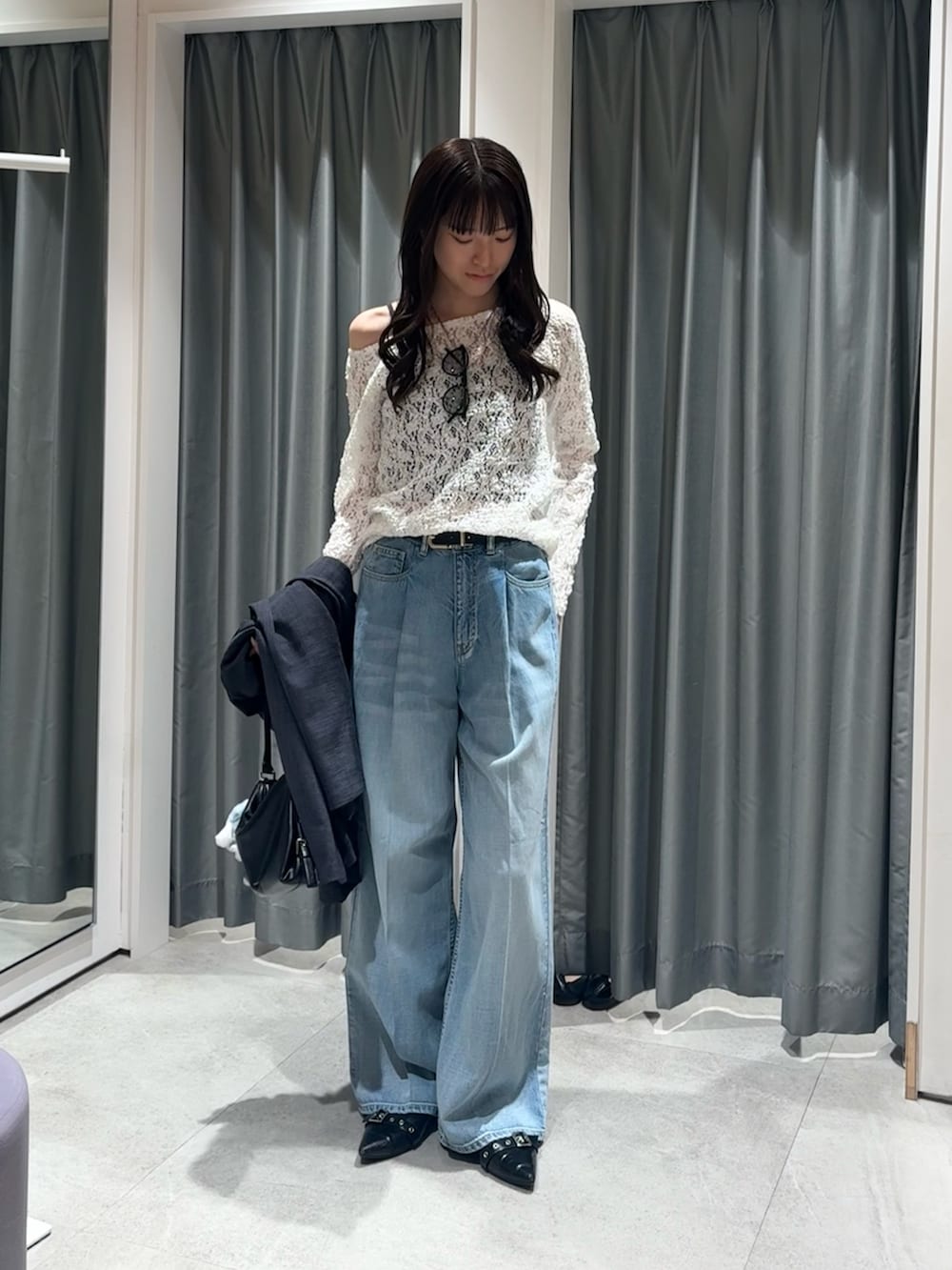 グレー系のテーラードジャケット、ホワイト系のTシャツ/カットソー、ブルー系のデニムパンツを着用したレディースの冬コーディネートの5枚目の写真