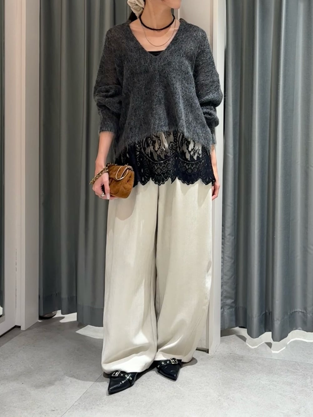 グレー系のニット/セーター、ブラック系のシャツ/ブラウス、ホワイト系のその他パンツを着用したレディースの冬コーディネートの3枚目の写真