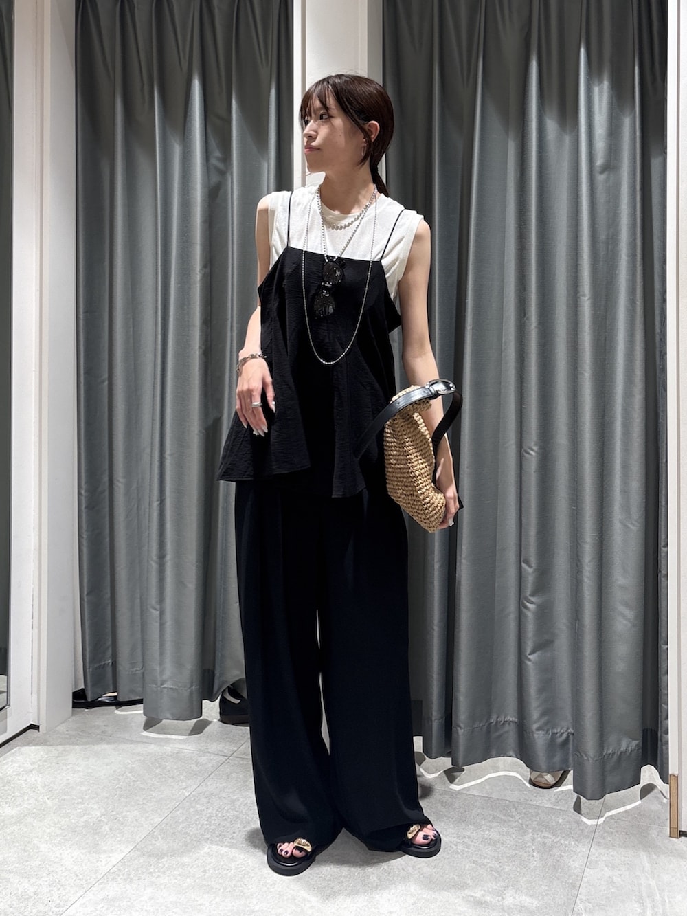 ホワイト系のTシャツ/カットソー、ブラック系のキャミソール、ブラック系のスラックスを着用したレディースの夏コーディネートの2枚目の写真