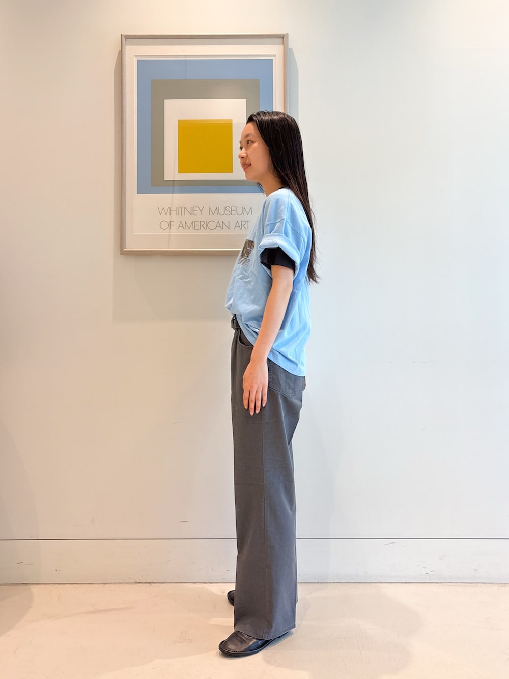 ブルー系のTシャツ/カットソー、グレー系のスラックス、ブラック系のバレエシューズを着用したレディースの夏コーディネートの2枚目の写真