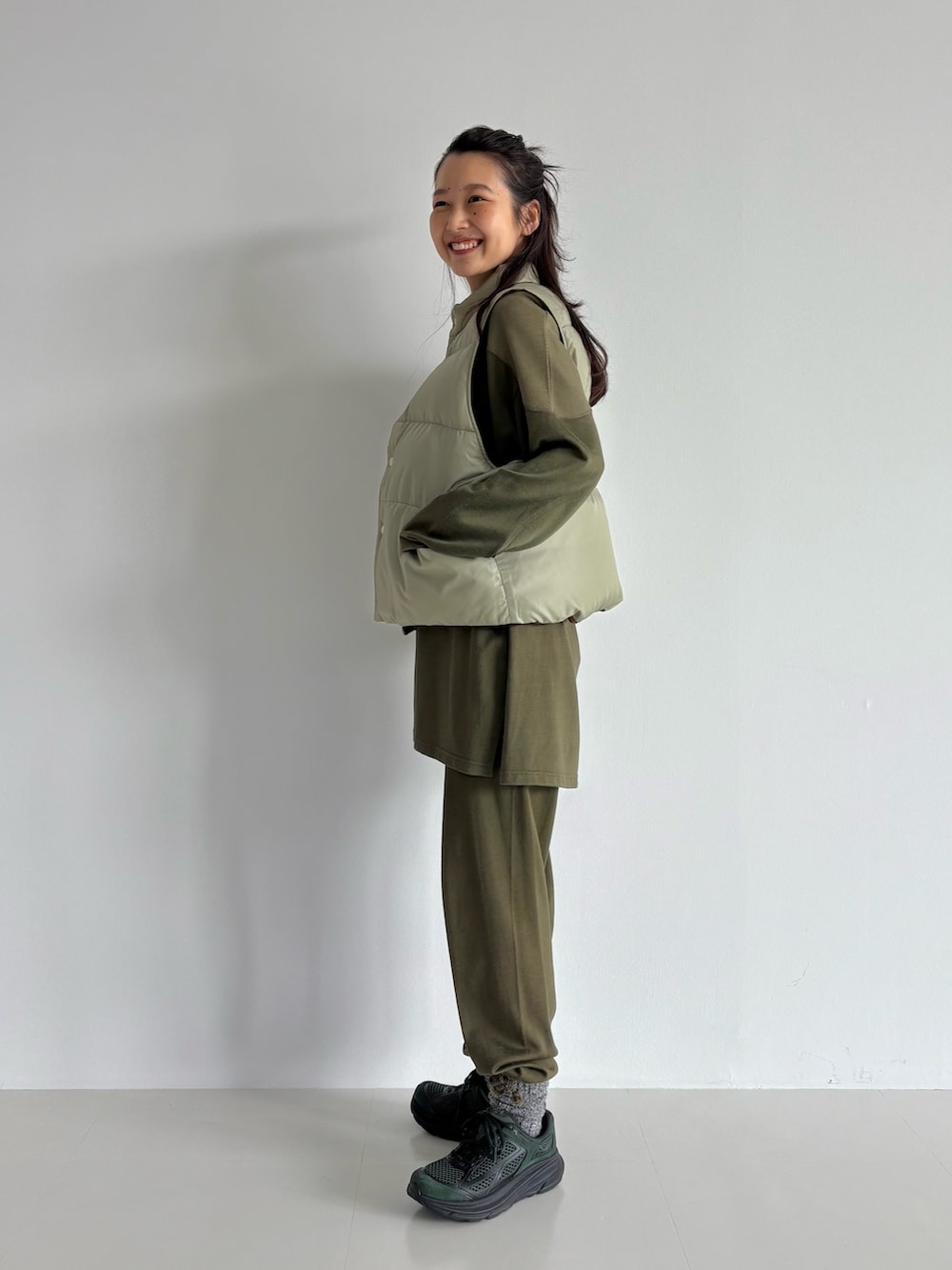 ブラウン系のダウンベスト、グリーン系のその他パンツ、グリーン系のTシャツ/カットソーを着用したレディースの秋コーディネートの2枚目の写真