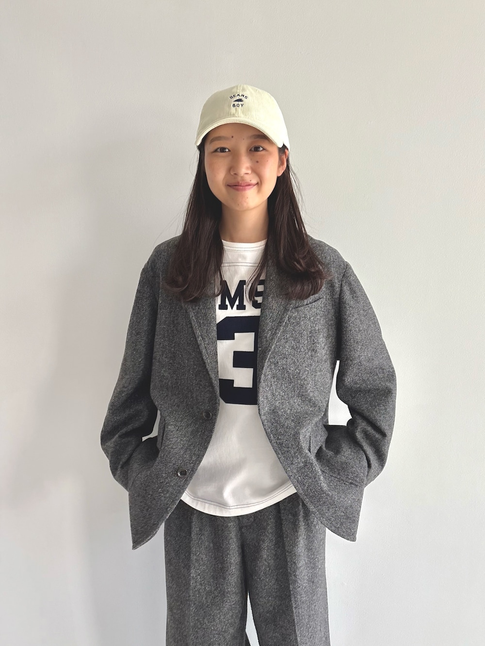 グレー系のテーラードジャケット、ホワイト系のTシャツ/カットソー、ブラウン系のスラックスを着用したレディースの秋コーディネートの4枚目の写真