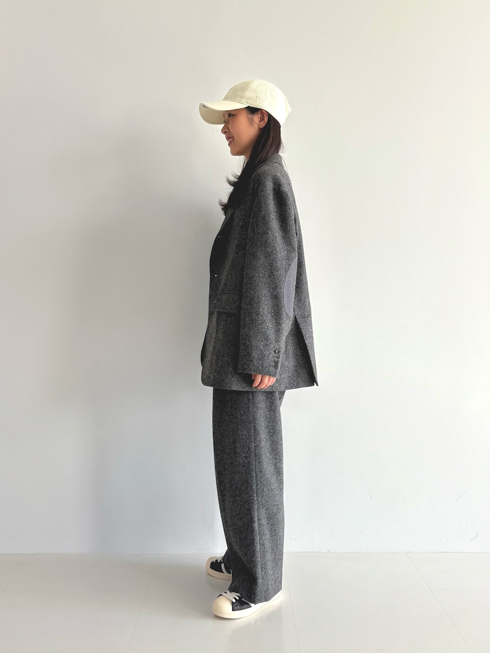 グレー系のテーラードジャケット、ホワイト系のTシャツ/カットソー、ブラウン系のスラックスを着用したレディースの秋コーディネートの2枚目の写真