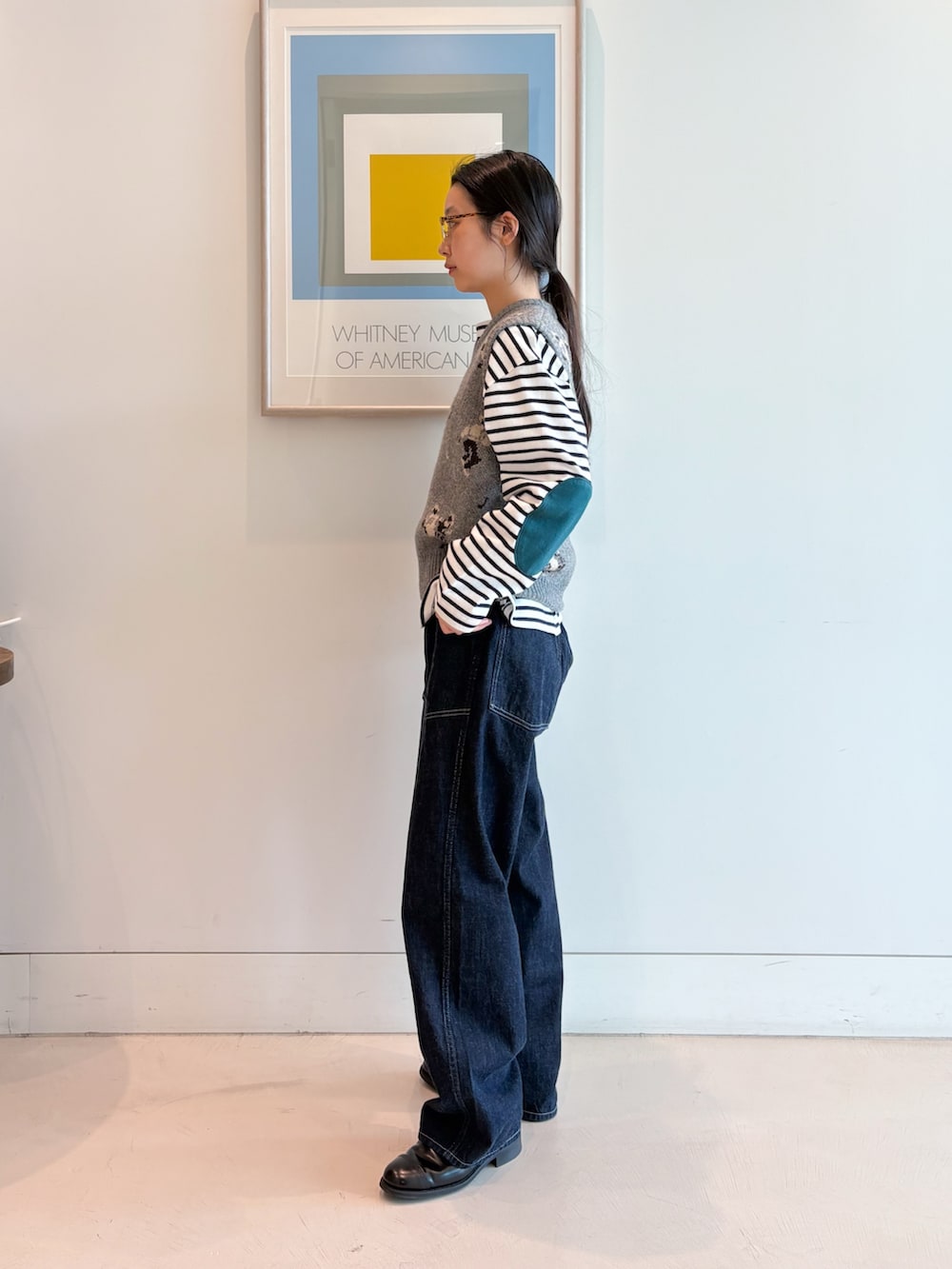 グレー系のベスト、ブルー系のデニムパンツ、ホワイト系のTシャツ/カットソーを着用したレディースの夏コーディネートの2枚目の写真