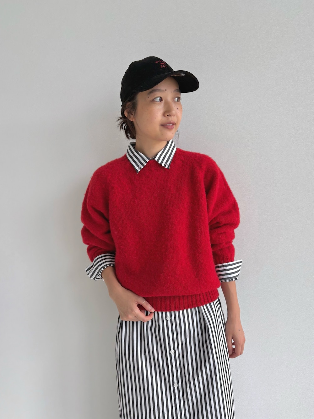 レッド系のニット/セーター、ブラック系のシャツワンピース、ブラウン系のモカシン/デッキシューズを着用したレディースの秋コーディネートの5枚目の写真