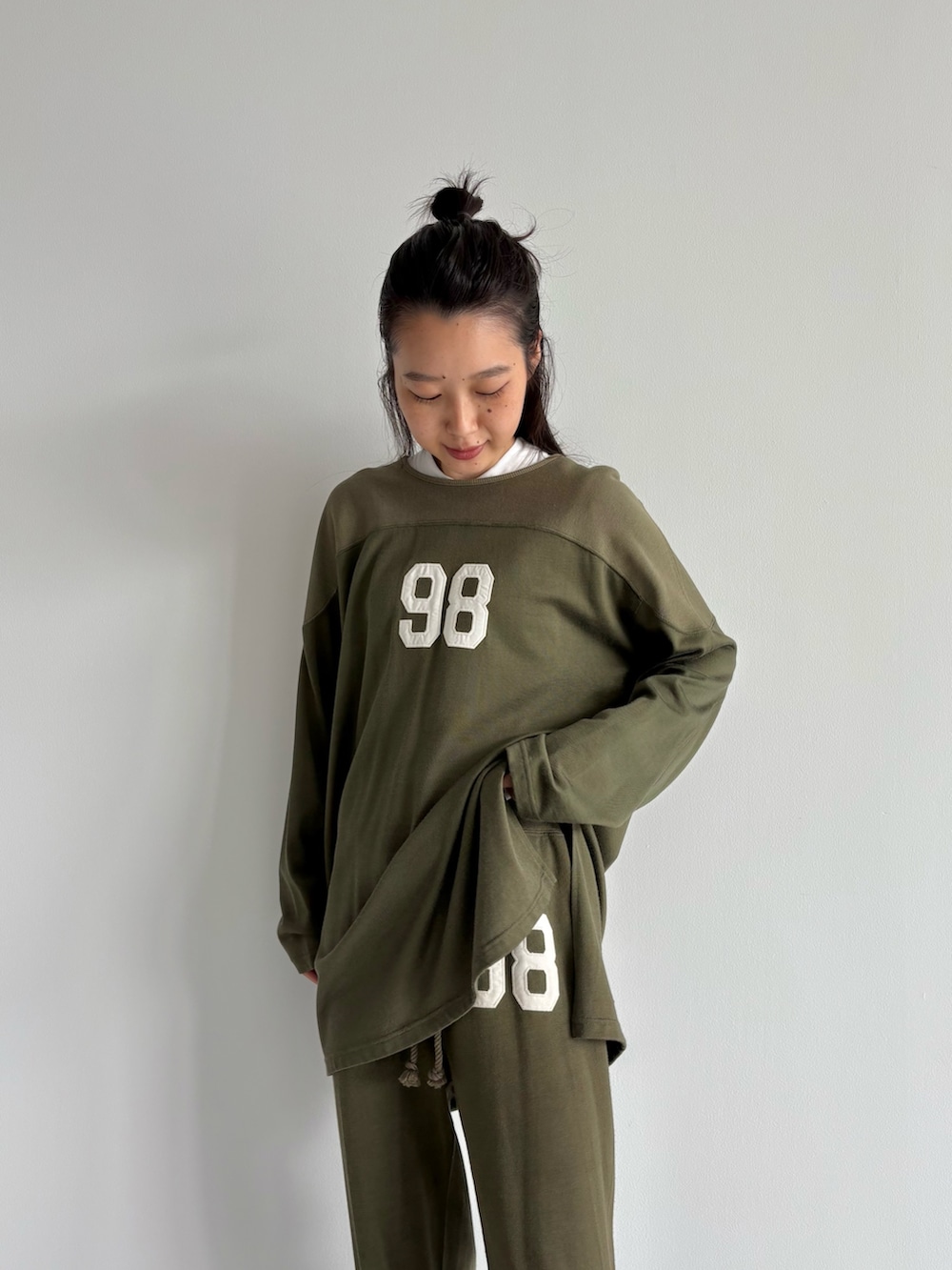 ブラウン系のダウンベスト、グリーン系のその他パンツ、グリーン系のTシャツ/カットソーを着用したレディースの秋コーディネートの5枚目の写真