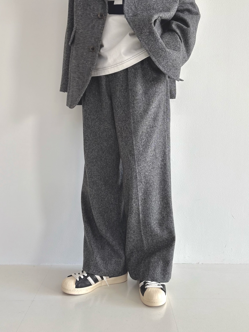 グレー系のテーラードジャケット、ホワイト系のTシャツ/カットソー、ブラウン系のスラックスを着用したレディースの秋コーディネートの6枚目の写真