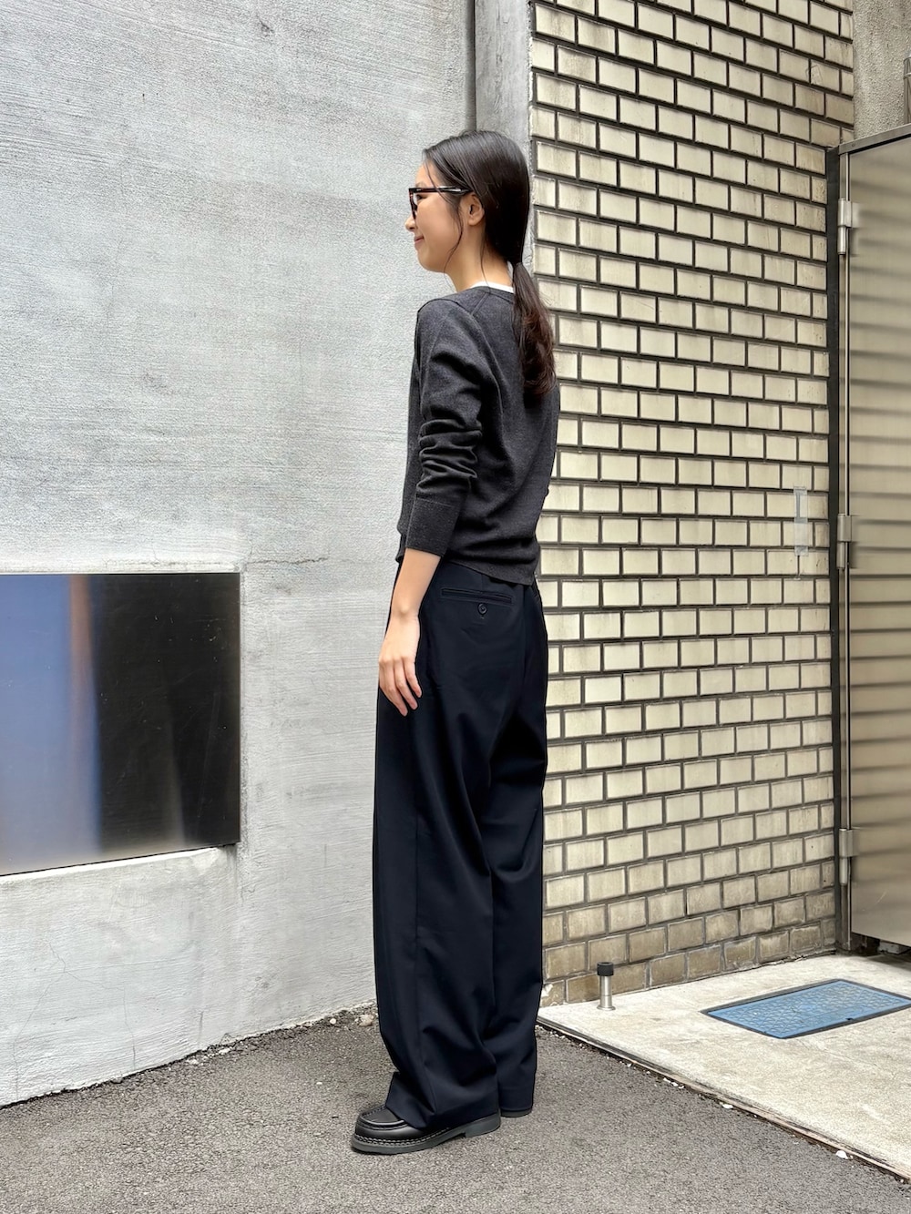 グレー系のカーディガン/ボレロ、ブルー系のスラックス、ブラック系のドレスシューズを着用したレディースの秋コーディネートの2枚目の写真