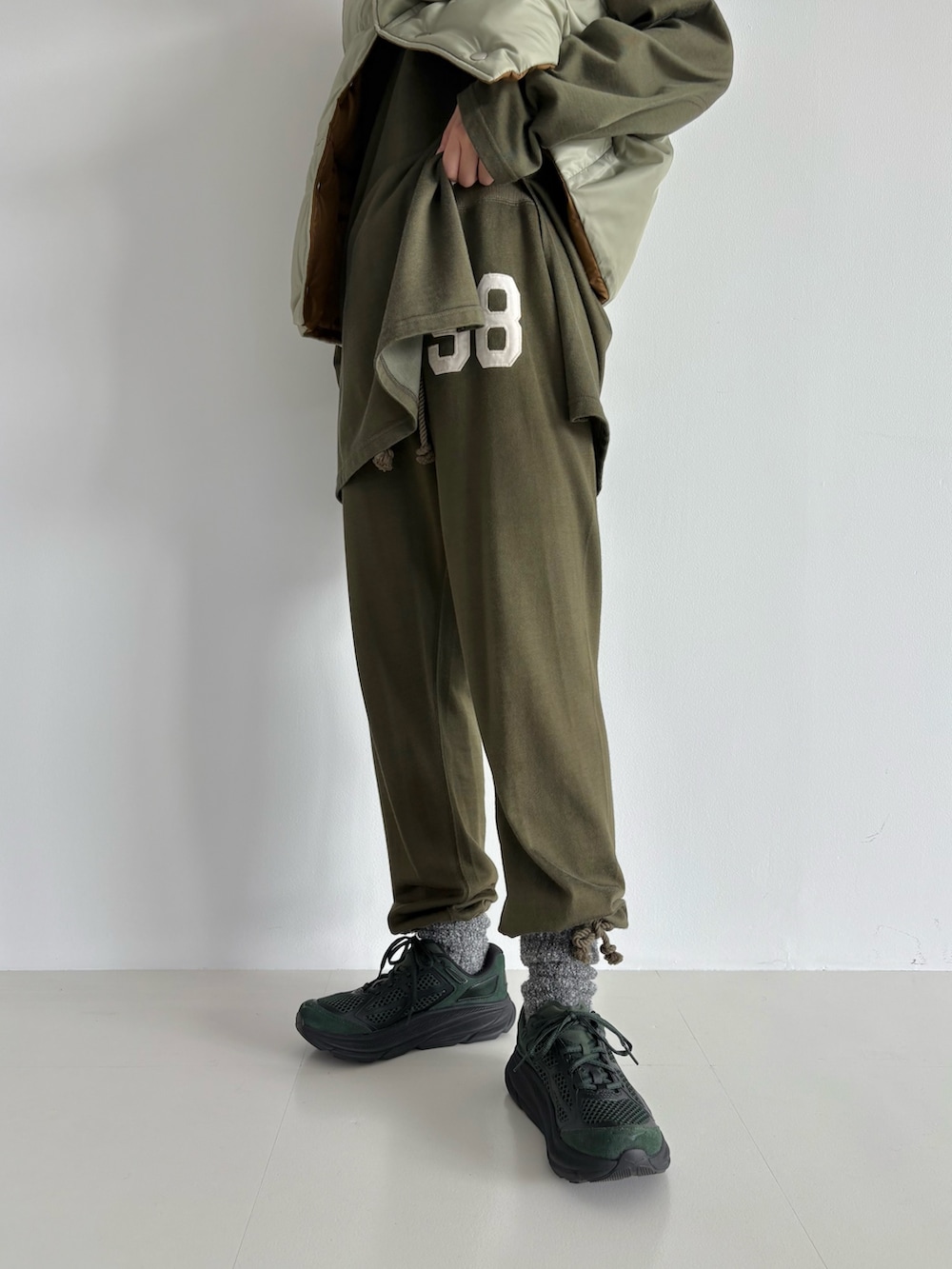 ブラウン系のダウンベスト、グリーン系のその他パンツ、グリーン系のTシャツ/カットソーを着用したレディースの秋コーディネートの6枚目の写真