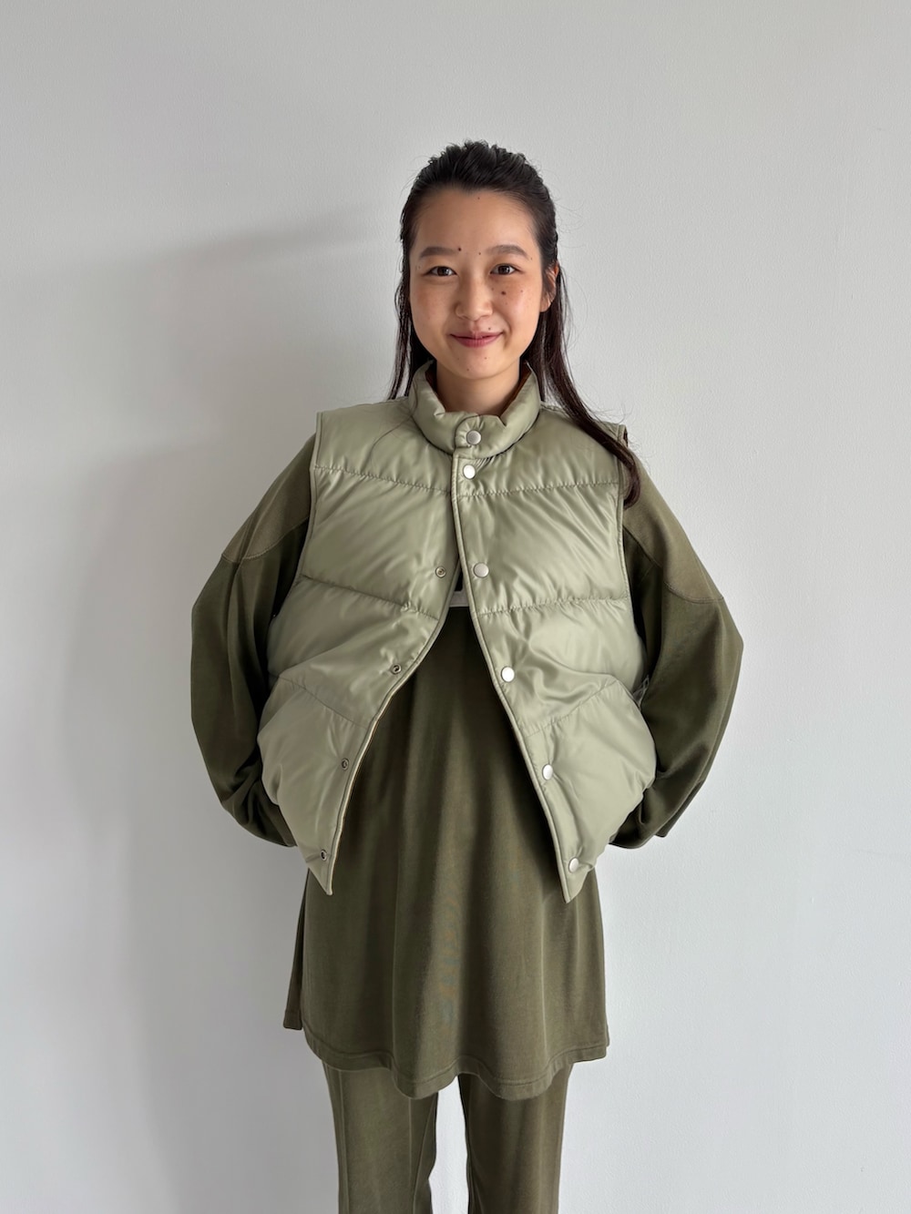 ブラウン系のダウンベスト、グリーン系のその他パンツ、グリーン系のTシャツ/カットソーを着用したレディースの秋コーディネートの4枚目の写真