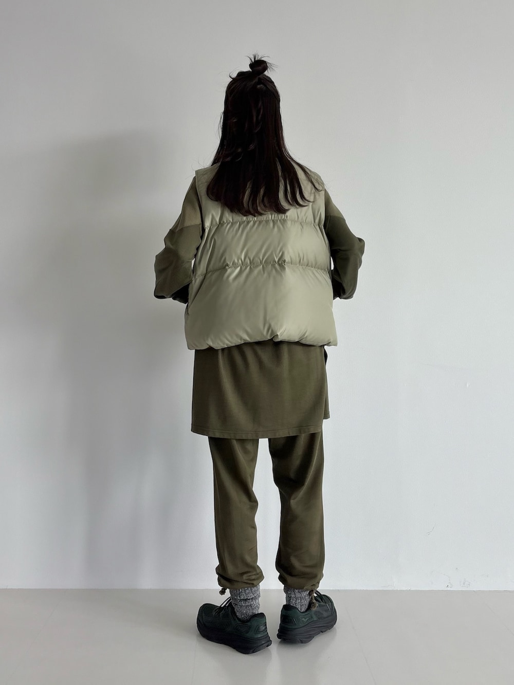 ブラウン系のダウンベスト、グリーン系のその他パンツ、グリーン系のTシャツ/カットソーを着用したレディースの秋コーディネートの3枚目の写真