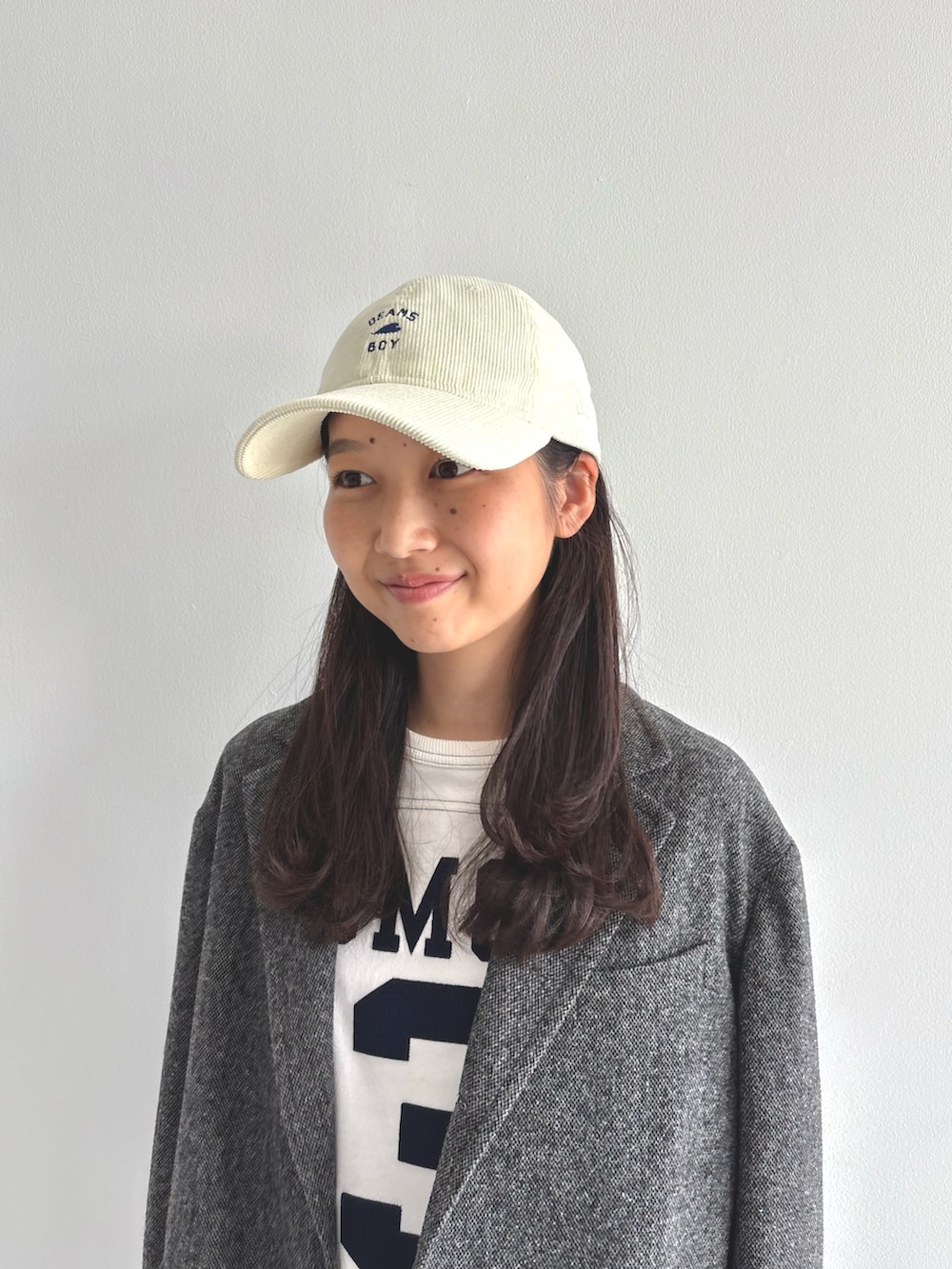 グレー系のテーラードジャケット、ホワイト系のTシャツ/カットソー、ブラウン系のスラックスを着用したレディースの秋コーディネートの5枚目の写真