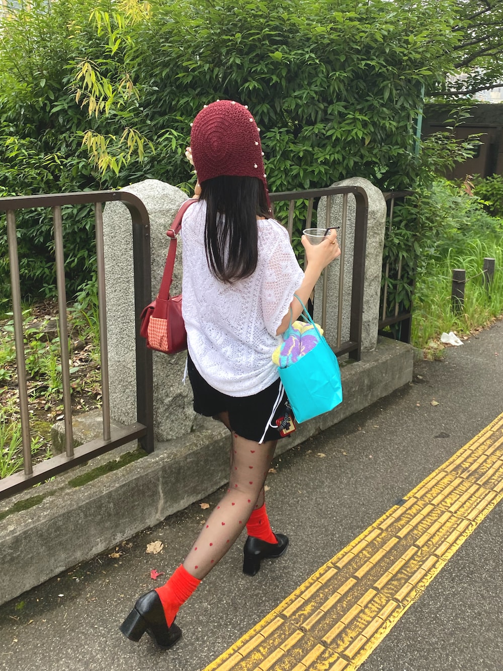 ホワイト系のニット/セーター、ブラック系のパンツ、ブラック系のローファーを着用したレディースの夏コーディネートの2枚目の写真