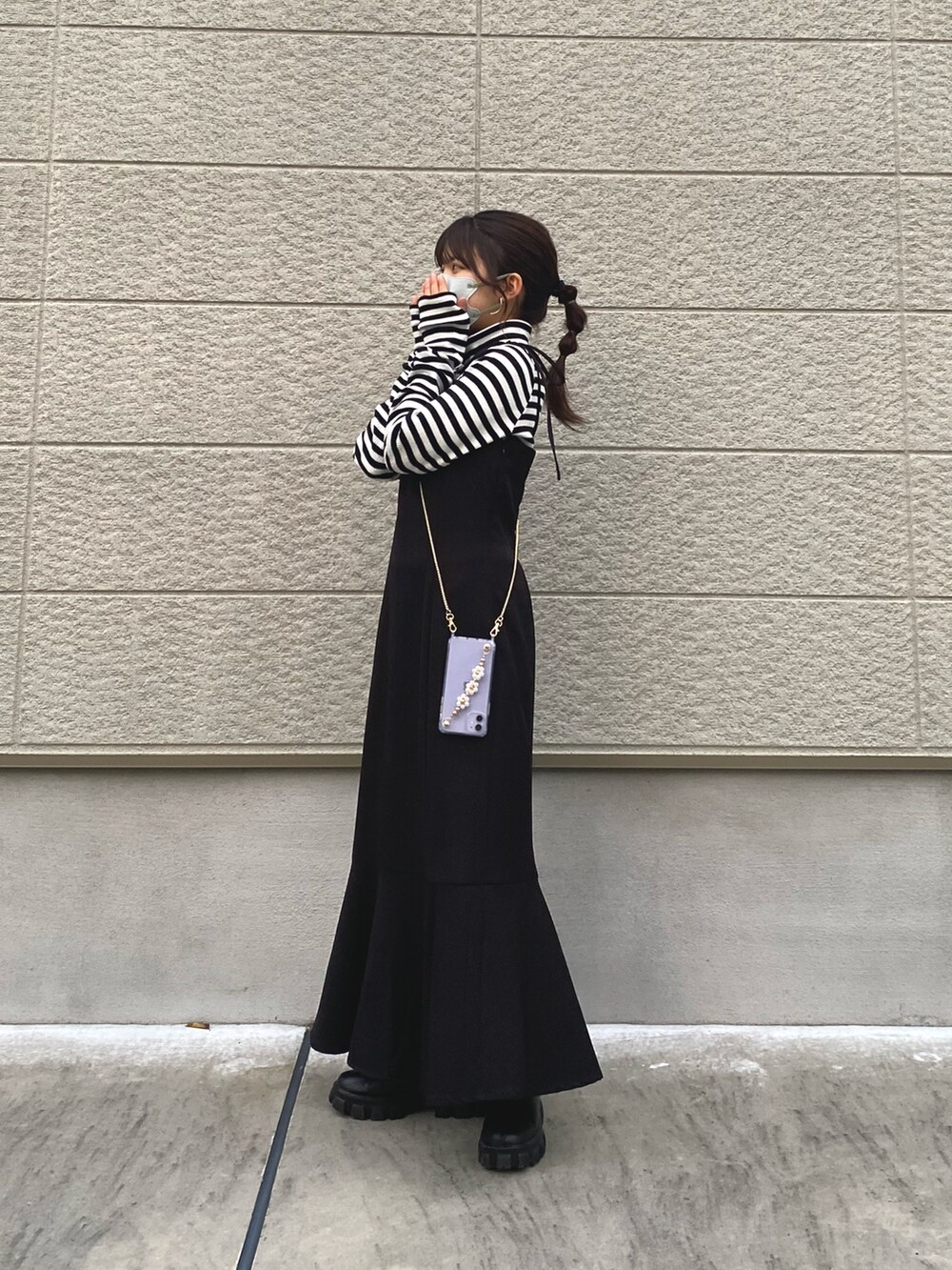 ホワイト系のノーカラージャケット、ブラック系のワンピース、ブラック系のブーツを着用したレディースの秋コーディネートの2枚目の写真