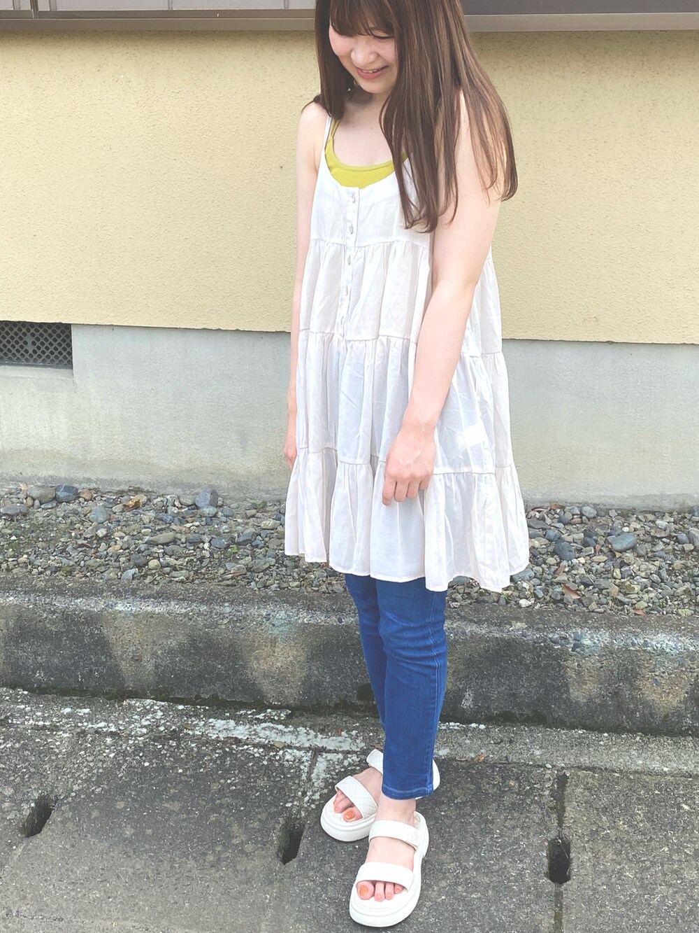 グリーン系のベスト、グリーン系のキャミソール、ベージュ系のワンピースを着用したレディースの夏コーディネートの2枚目の写真