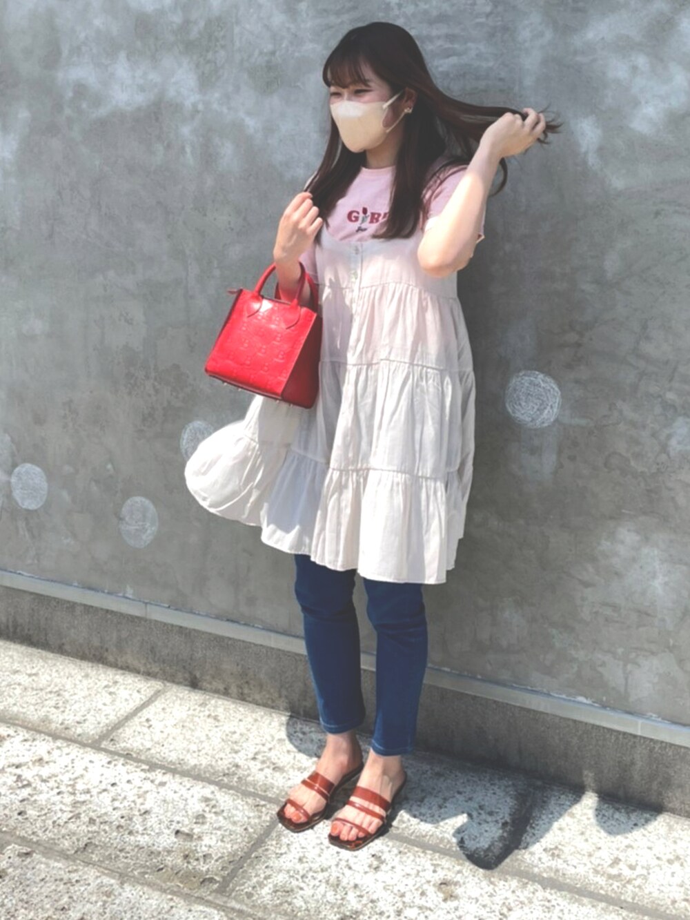 ピンク系のTシャツ/カットソー、ベージュ系のワンピース、ブルー系のデニムパンツを着用したレディースの夏コーディネートの2枚目の写真