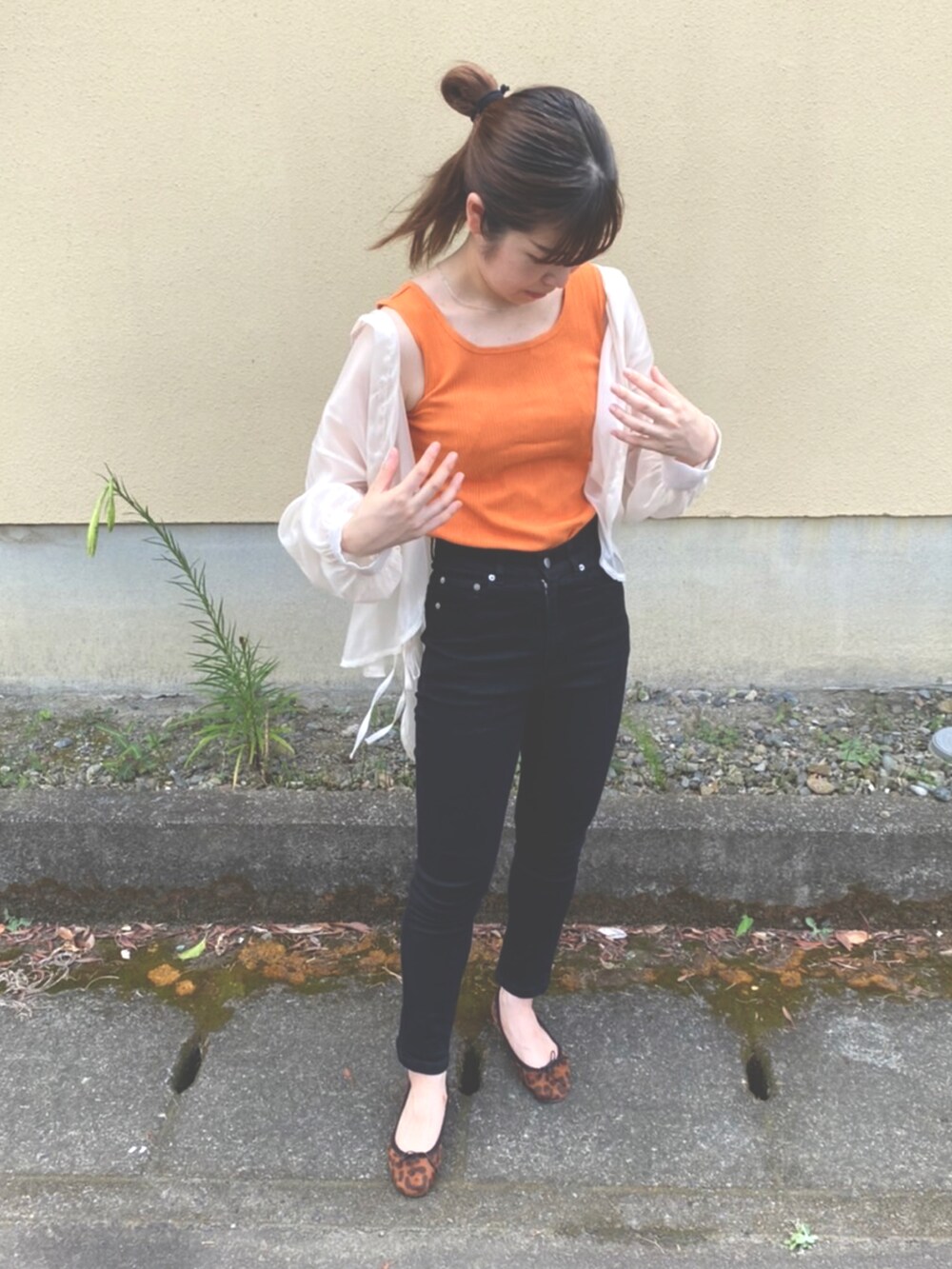 オレンジ系のタンクトップ、ブラック系のデニムパンツ、ブラウン系のパンプスを着用したレディースの夏コーディネートの2枚目の写真