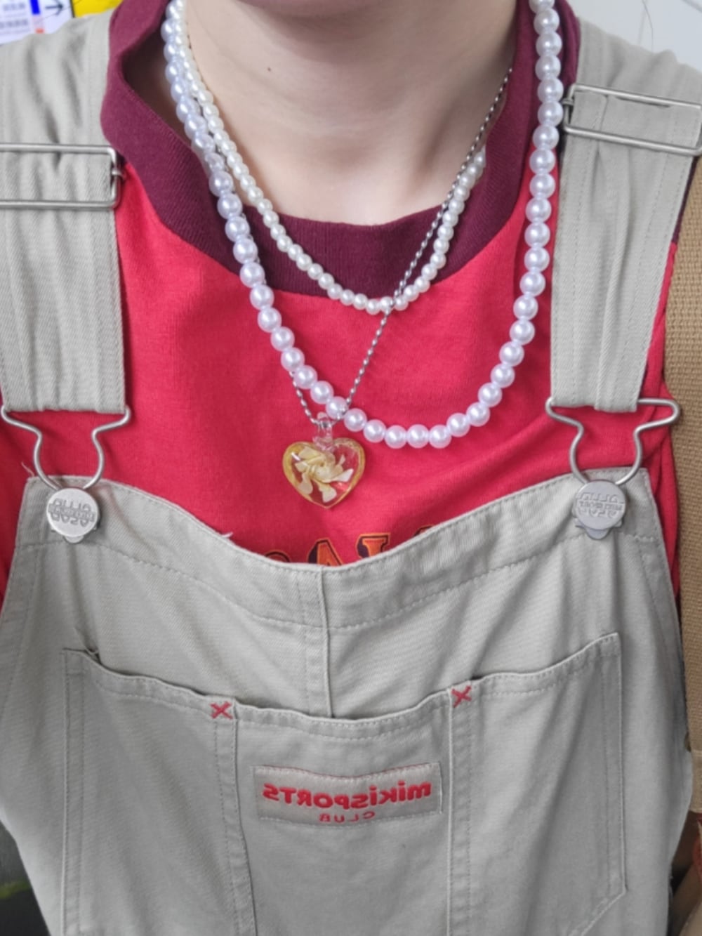 ベージュ系のサロペット/オーバーオール、グリーン系のショルダーバッグ、ブラウン系のサンダルを着用したレディースの夏コーディネートの2枚目の写真