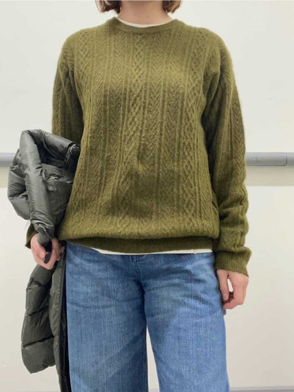 ホワイト系のTシャツ/カットソー、グリーン系のダウンベスト、グリーン系のニット/セーターを着用したレディースの冬コーディネートの4枚目の写真