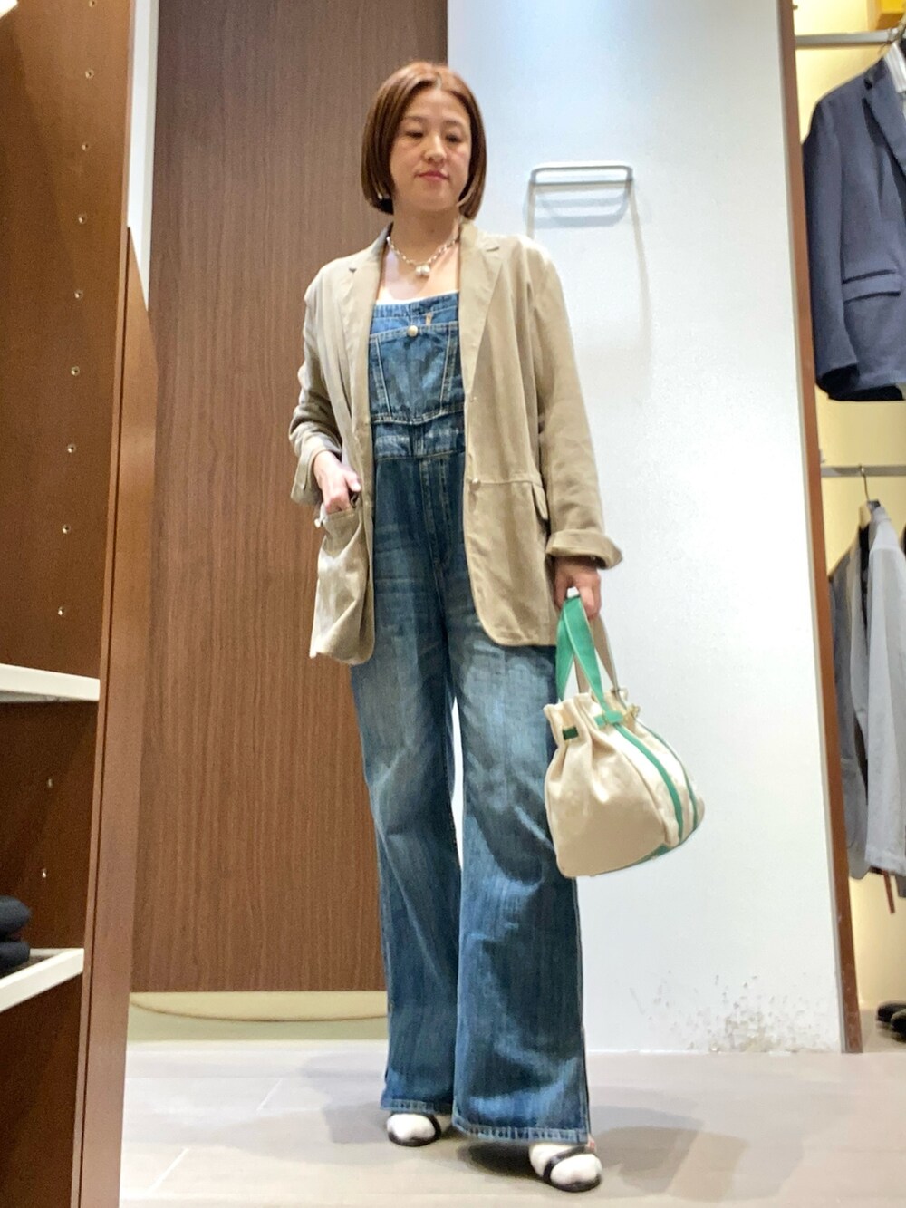 グリーン系のトートバッグを着用したレディースの春コーディネートの2枚目の写真