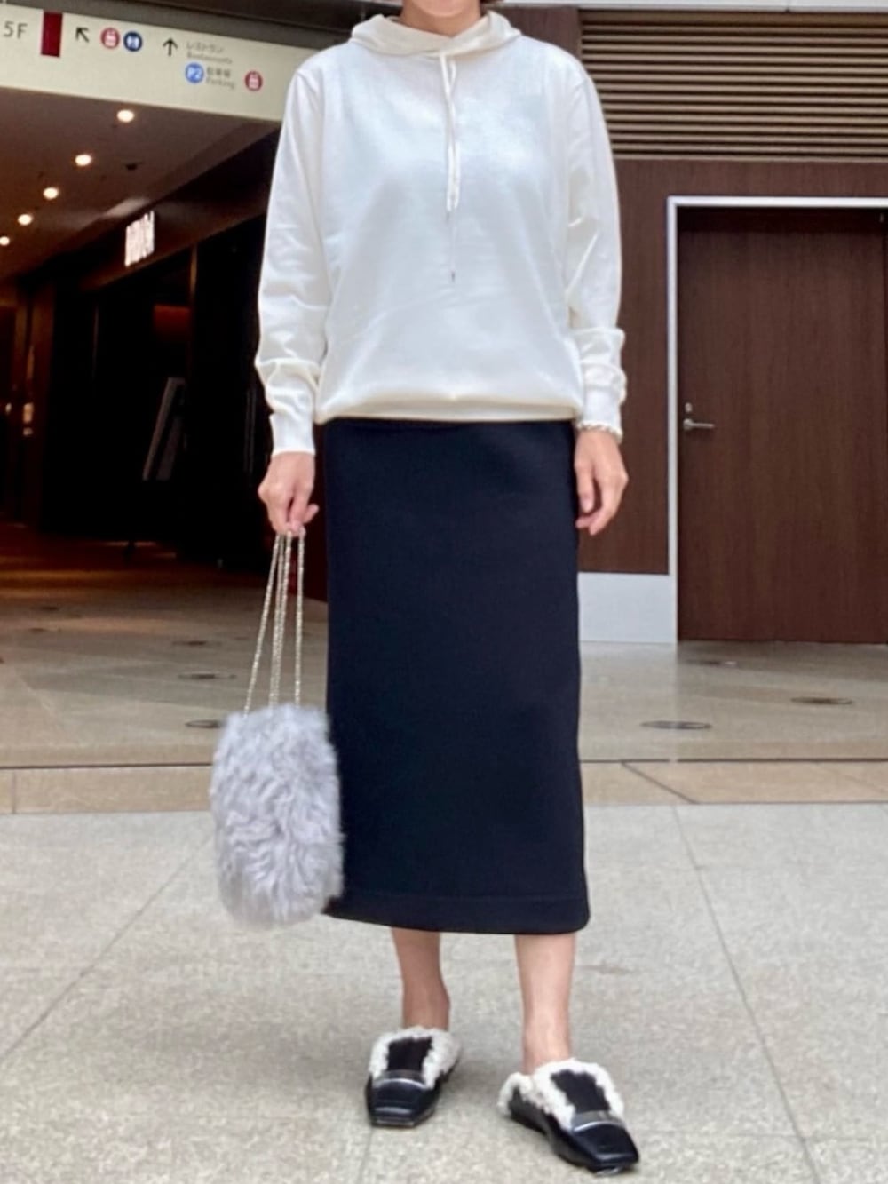 ホワイト系のパーカーを着用したレディースの冬コーディネートの2枚目の写真