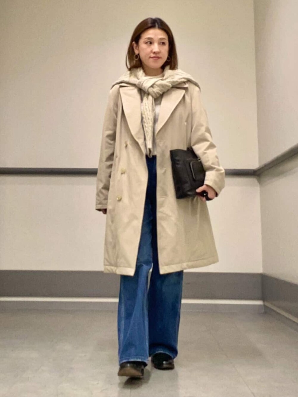 ホワイト系のニット/セーター、ホワイト系のニット/セーター、ホワイト系のステンカラーコートを着用したレディースの冬コーディネートの2枚目の写真