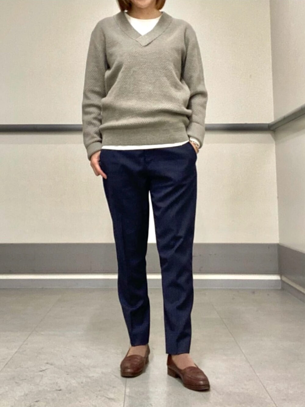 グレー系のニット/セーター、ホワイト系のTシャツ/カットソーを着用したレディースの冬コーディネートの2枚目の写真