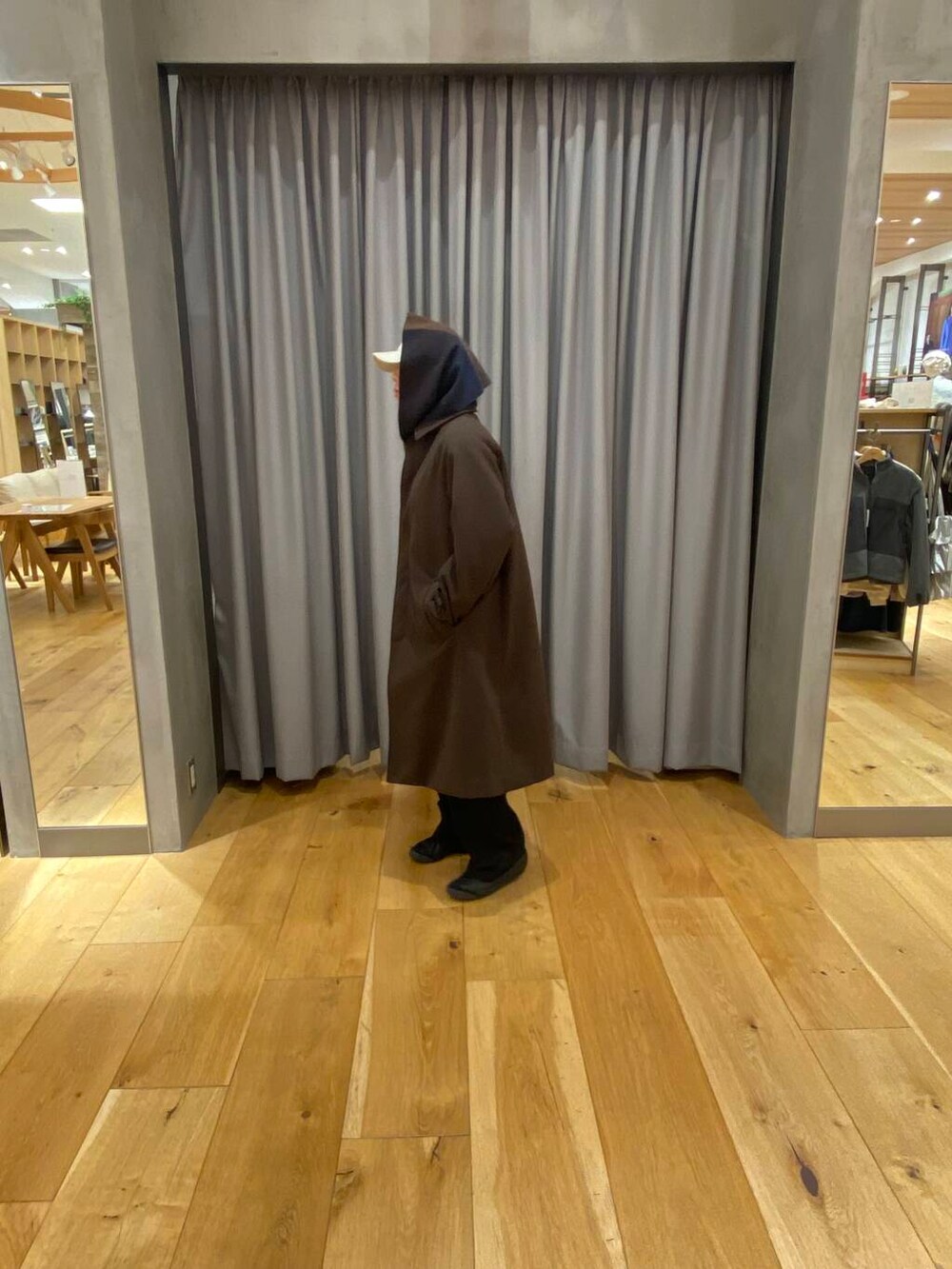 ブラウン系のステンカラーコート、ブラウン系のマフラー、ベージュ系のキャップを着用したメンズの冬コーディネートの3枚目の写真