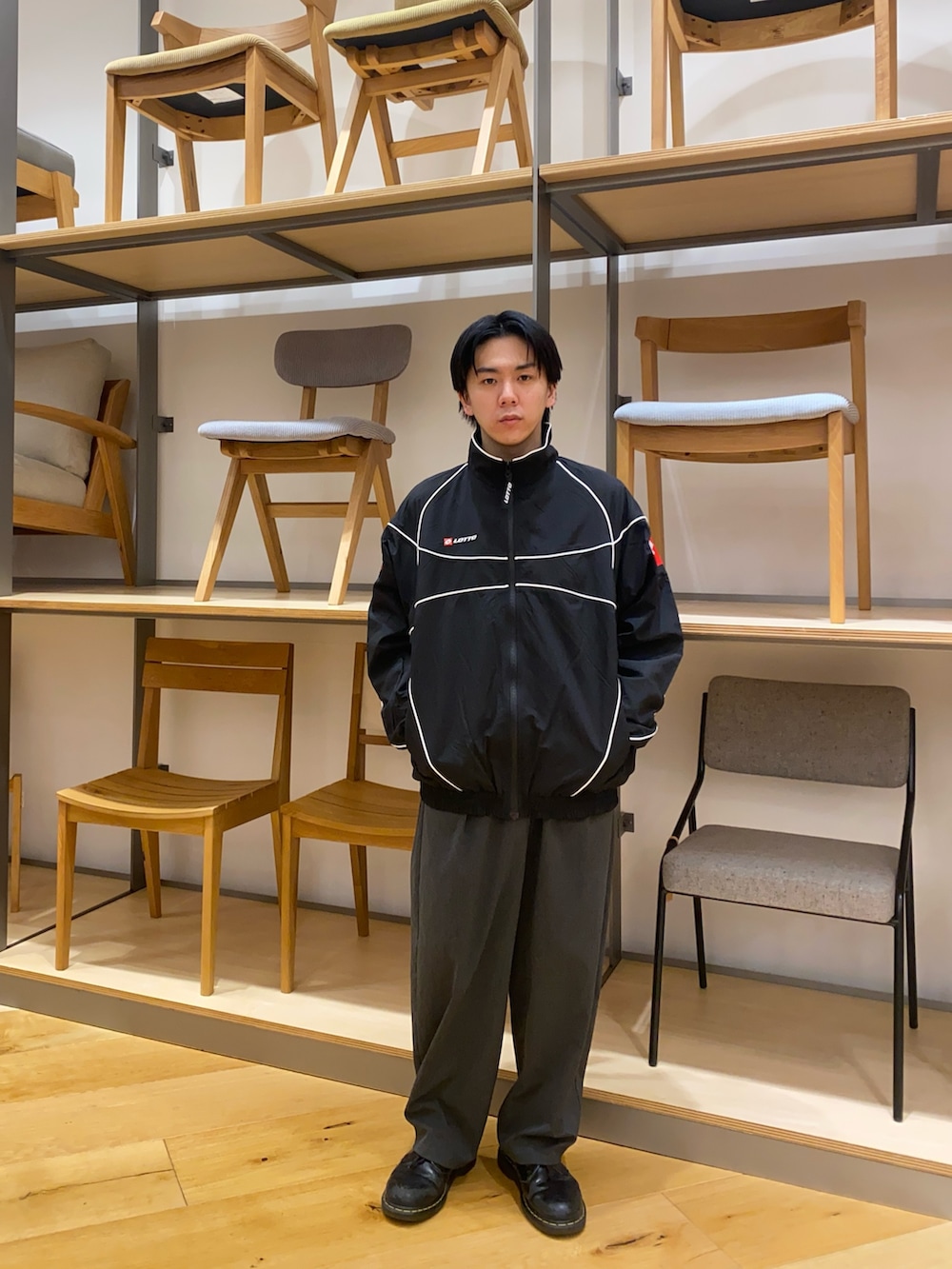 ブラック系のナイロンジャケットを着用したメンズの春コーディネートの2枚目の写真