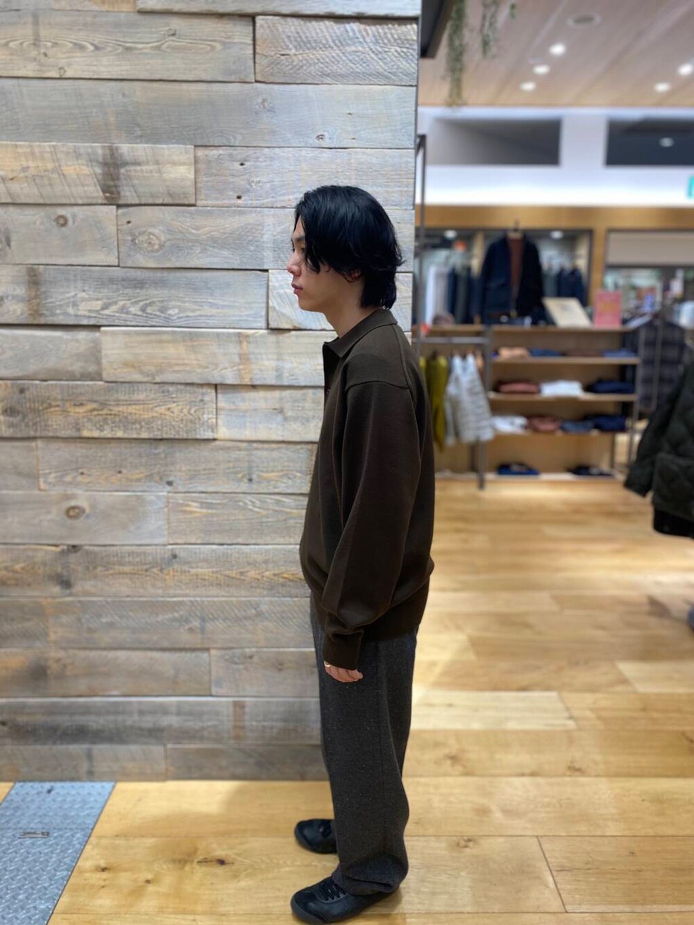 ブラウン系のポロシャツ、グレー系のその他パンツを着用したメンズの冬コーディネートの4枚目の写真