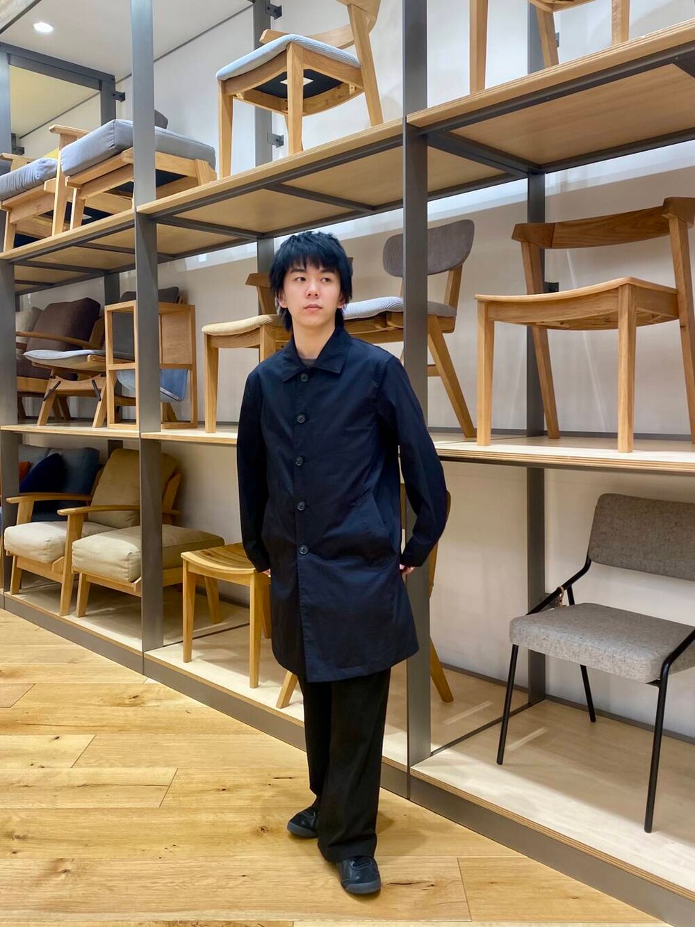 ブラック系のステンカラーコートを着用したメンズの春コーディネートの3枚目の写真