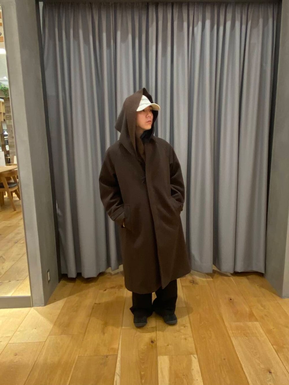 ブラウン系のステンカラーコート、ブラウン系のマフラー、ベージュ系のキャップを着用したメンズの冬コーディネートの2枚目の写真