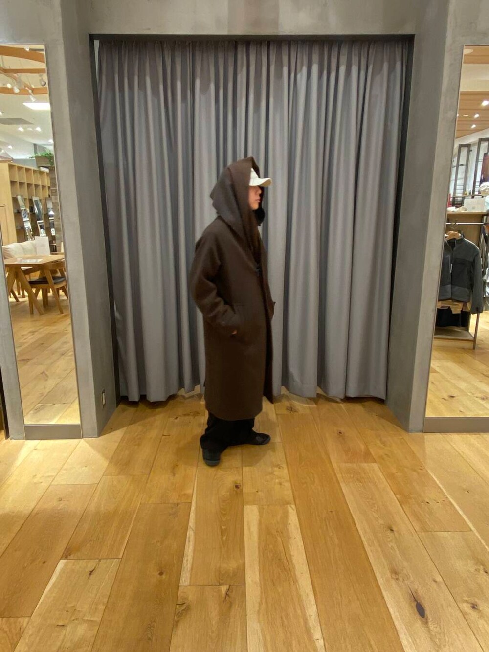 ブラウン系のステンカラーコート、ブラウン系のマフラー、ベージュ系のキャップを着用したメンズの冬コーディネートの4枚目の写真