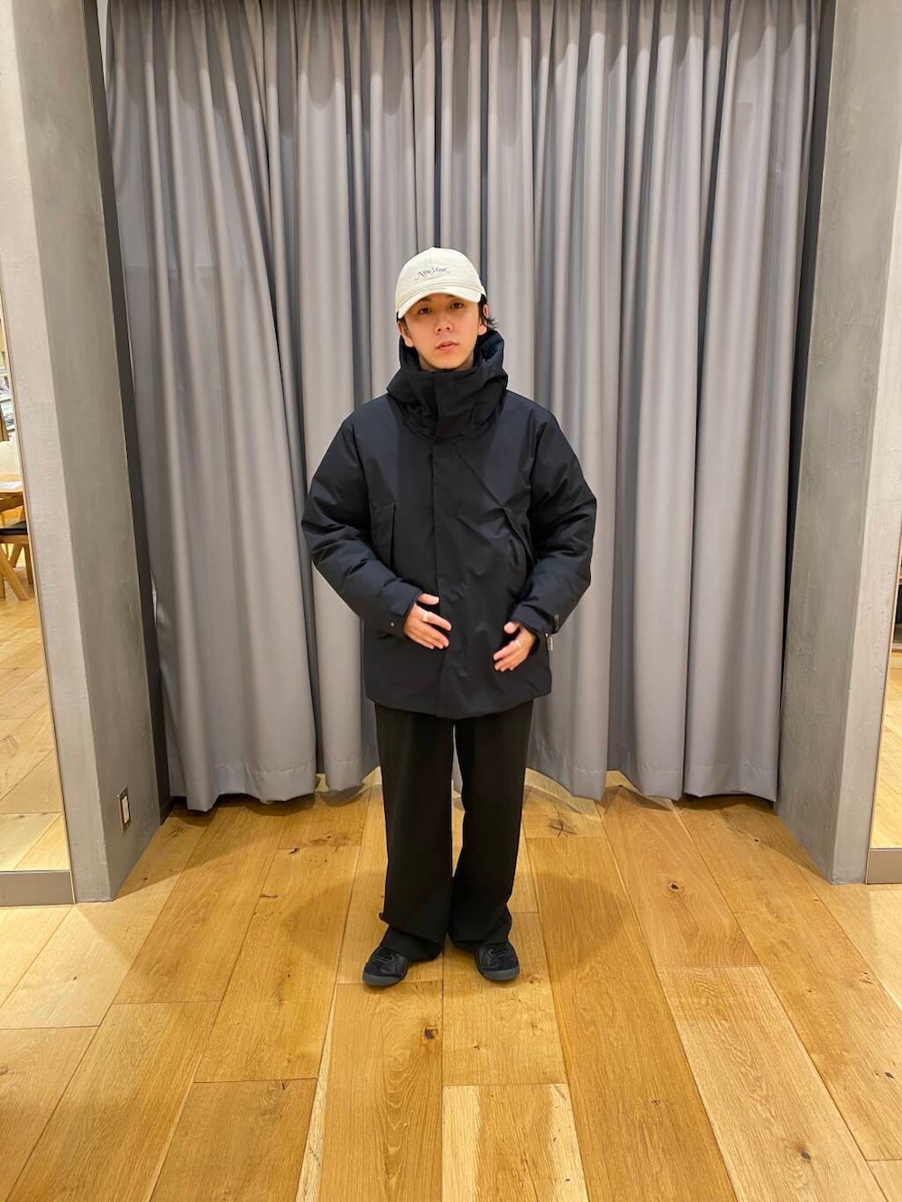 ブラック系のダウンジャケット/コート、ベージュ系のキャップを着用したメンズの冬コーディネートの2枚目の写真