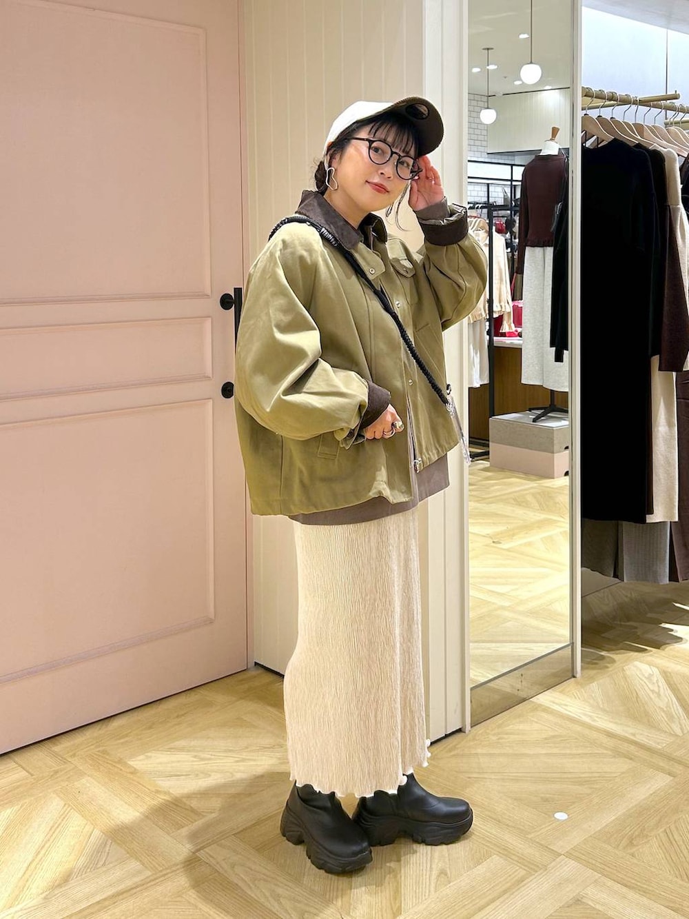 ブラック系のブーツ、ブラウン系のスウェット、ブラウン系のその他アウターを着用したレディースの秋コーディネートの6枚目の写真