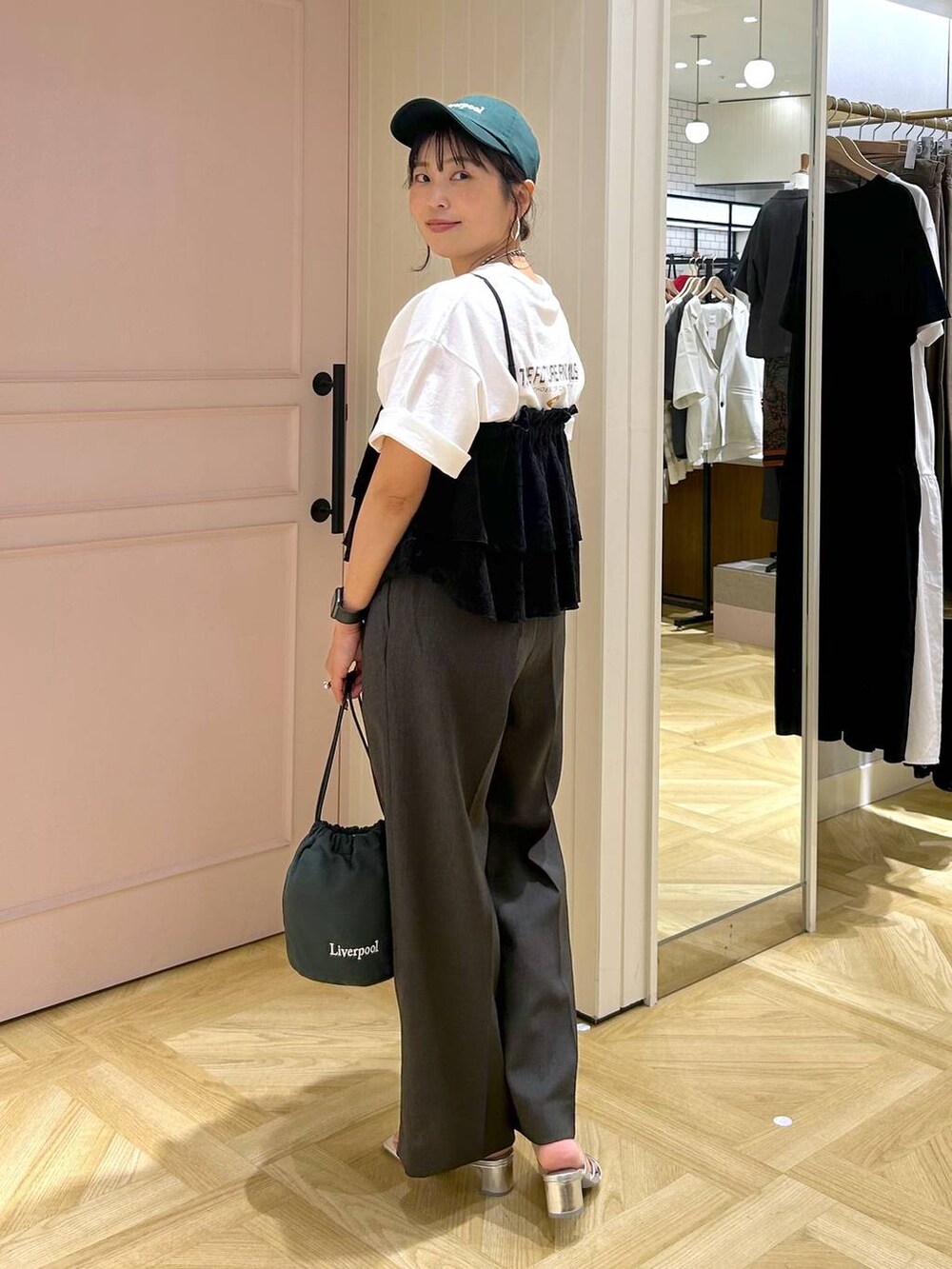 グレー系のスラックス、シルバー系のサンダル、ホワイト系のTシャツ/カットソーを着用したレディースの夏コーディネートの5枚目の写真