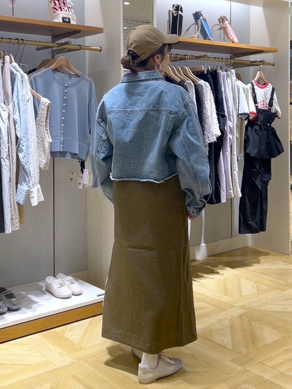 ブラウン系のスカート、ブルー系のデニムジャケット、ホワイト系のスニーカーを着用したレディースの春コーディネートの3枚目の写真