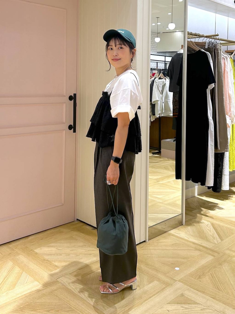 グレー系のスラックス、シルバー系のサンダル、ホワイト系のTシャツ/カットソーを着用したレディースの夏コーディネートの4枚目の写真