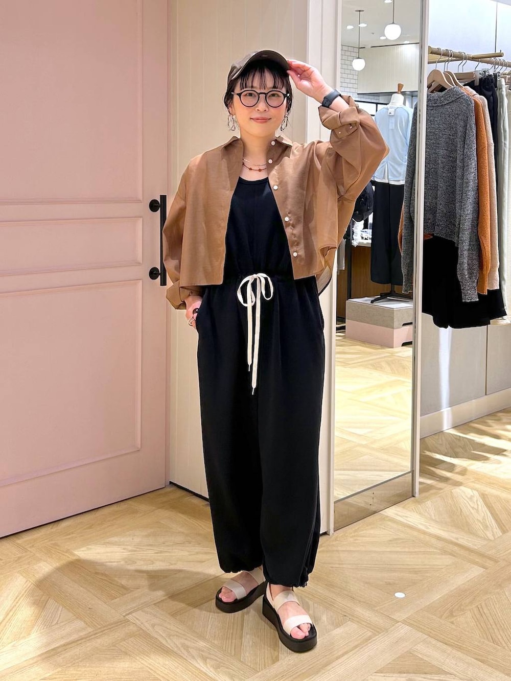 ブラウン系のシャツ/ブラウス、ホワイト系のサンダル、ブラック系のサロペット/オーバーオールを着用したレディースの春コーディネートの6枚目の写真