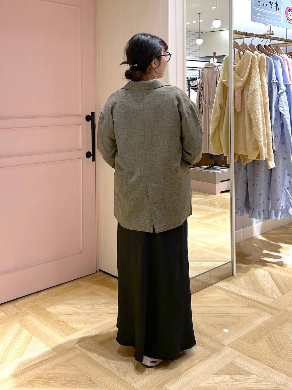 ブラック系のタンクトップ、ブラック系のスカート、ブラウン系のテーラードジャケットを着用したレディースの冬コーディネートの4枚目の写真