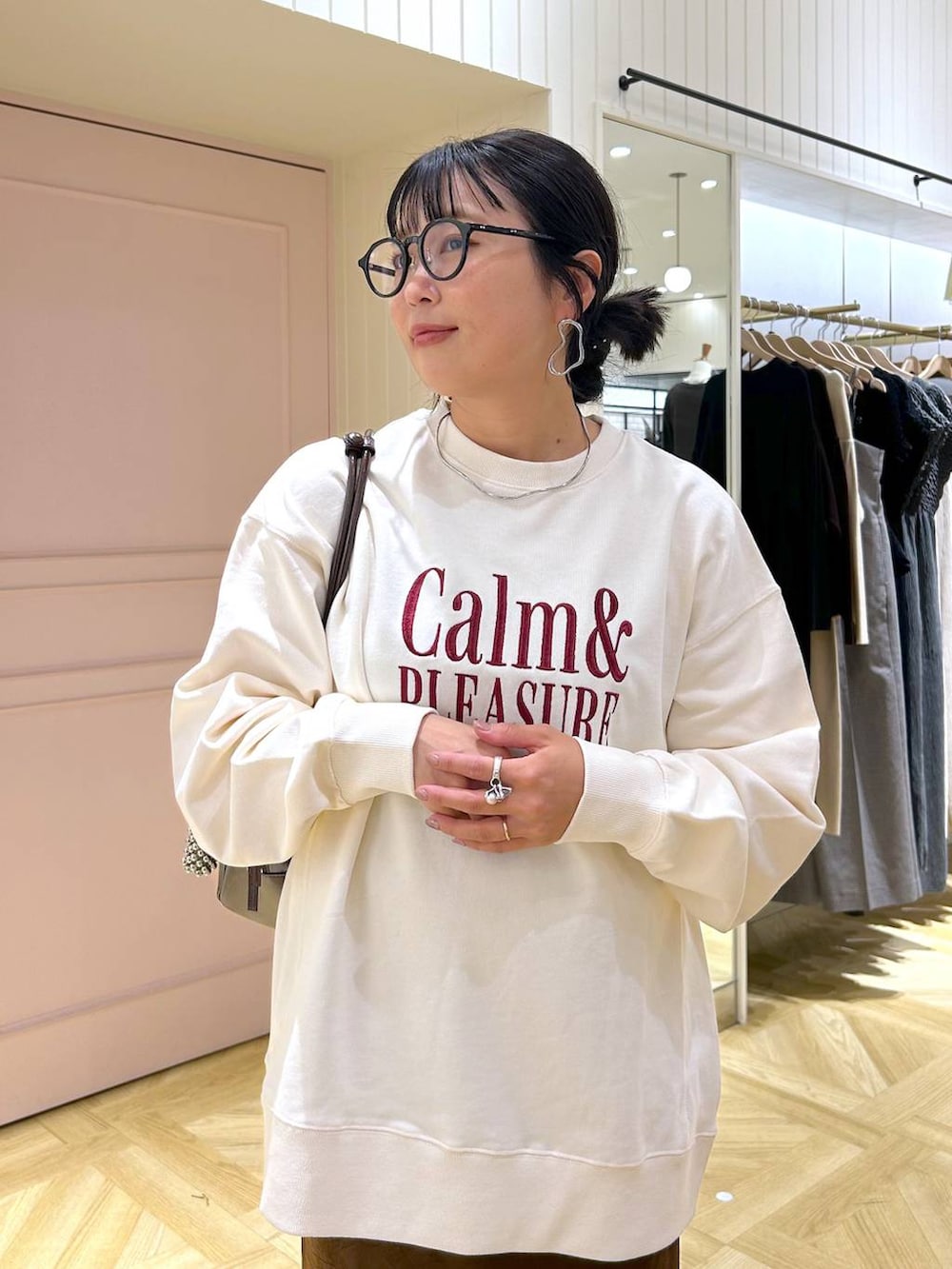 ブラウン系のスカート、ホワイト系のスウェット、ブラック系のローファーを着用したレディースの秋コーディネートの7枚目の写真