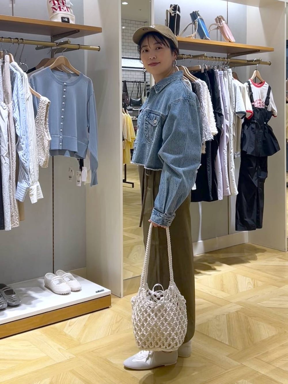 ブラウン系のスカート、ブルー系のデニムジャケット、ホワイト系のスニーカーを着用したレディースの春コーディネートの2枚目の写真