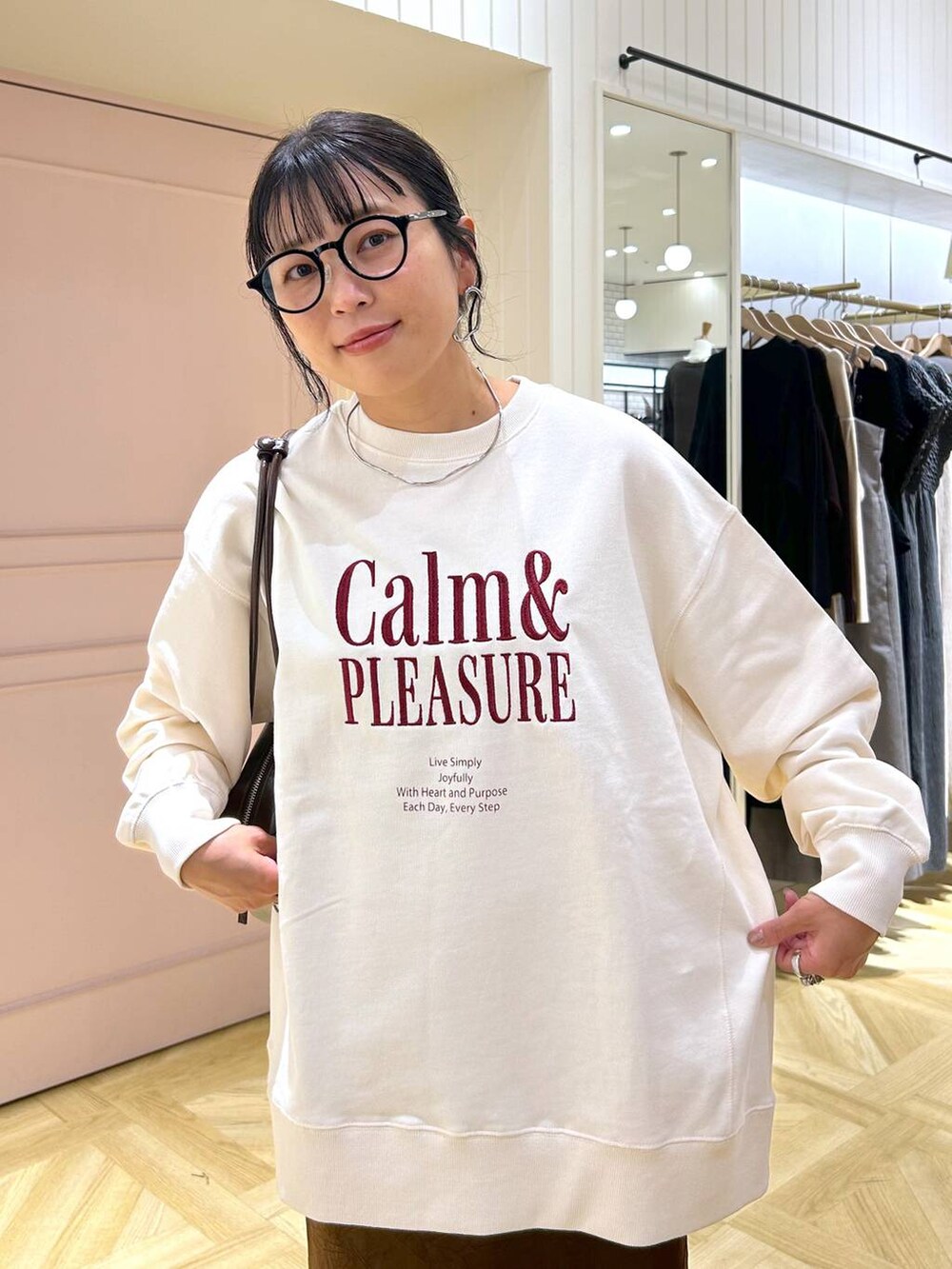 ブラウン系のスカート、ホワイト系のスウェット、ブラック系のローファーを着用したレディースの秋コーディネートの2枚目の写真